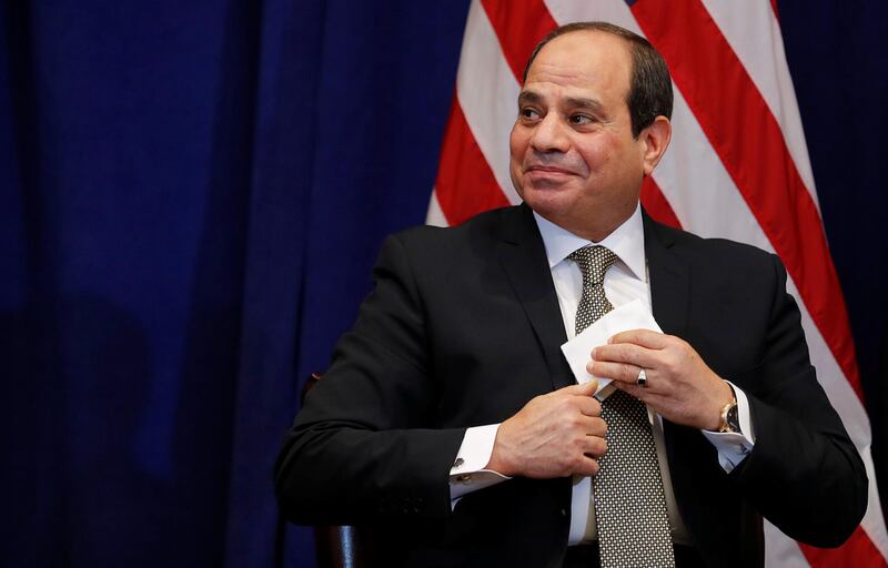 Egypt's President Abdel Fattah El Sisi tucks away a cloth after wiping his face during a bilateral meeting with US President Donald Trump on the sidelines. Reuters