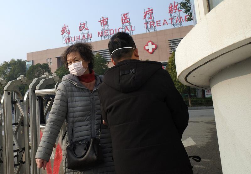 A woman (L) leaves the Wuhan Medical Treatment Centre, where a man who died from a respiratory illness was confined, in the city of Wuhan, Hubei province, on January 12, 2020. - A 61-year-old man has become the first person to die in China from a respiratory illness believed caused by a new virus from the same family as SARS, which claimed hundreds of lives more than a decade ago, authorities said. (Photo by Noel Celis / AFP)