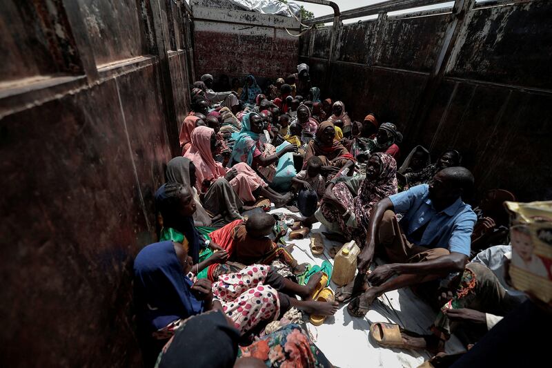 Sudanese refugees sit on a truck that will relocate them to a refugee camp in Adre, Chad.
