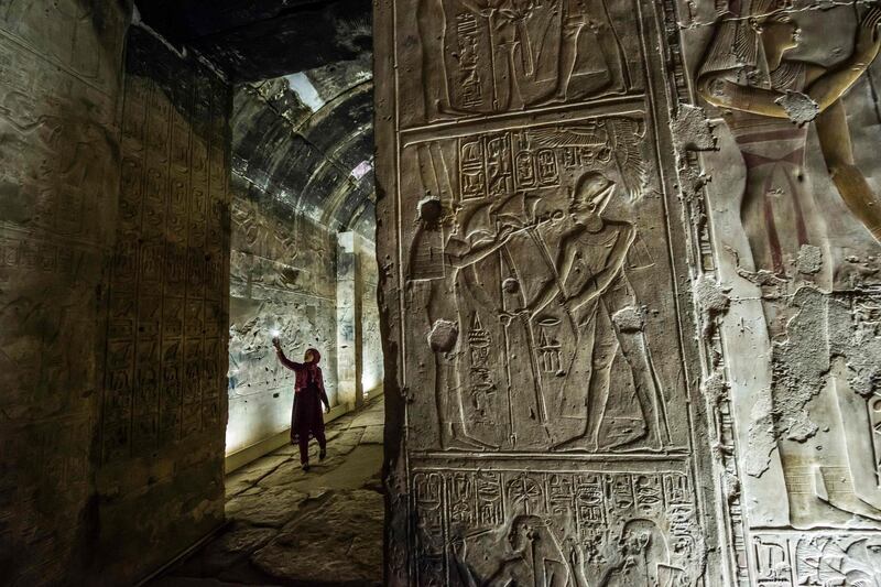 A visitor uses her phone to take a picture inside the New Kingdom period (16th-11th centuries BC) Temple of Seti I, while touring in the archaeological site of Abydos near Egypt's southern city of Sohag, about 540 kilometres from the capital Cairo.  AFP