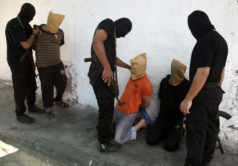 Hamas militants grab Palestinians suspected of collaborating with Israel, before executing them in Gaza City on August 22, 2014. Reuters
