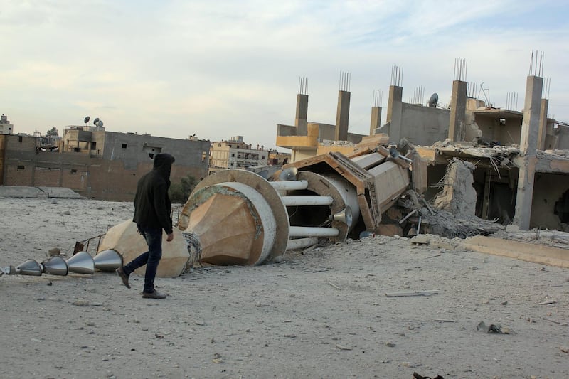 A Syrian man walks past a minaret destroyed following an alleged air strikes by Syrian government forces in the Islamic State (IS) group controlled Syrian city of Raqa, on November 25, 2014. A string of Syrian regime air strikes on the Islamic State group's self-proclaimed capital Raqa killed at least 63 people, more than half of them civilians, a monitor said. The air strikes were the deadliest by President Bashar al-Assad's air force against Raqa since the Sunni extremist IS seized control of the city last year.  AFP PHOTO/RMC/STR (Photo by STR / Raqa Media Center / AFP)