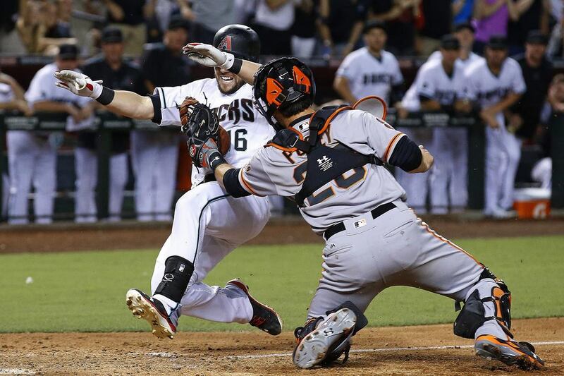 San Francisco Giants’ Buster Posey, right, tags out Arizona Diamondbacks’ Chris Owings, as Owings tried to score during the seventh inning of a baseball game in Phoenix. Ross D Franklin / AP Photo