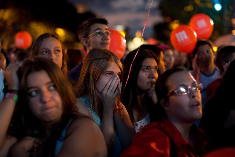 Girls react as they gather next to others in front of big screens at Puerta de Alcala in Madrid, Spain Saturday Sept. 7, 2013. Madrid has been eliminated as a host city for the 2020 Olympics, leaving Tokyo and Istanbul to advance to the final round. Madrid initially tied with Istanbul as an also-ran in the voting by the International Olympic Committee. Istanbul won the tiebreak vote 49-45. The winner will now be determined in a second-round vote between the Japanese and Turkish cities.  (AP Photo/Daniel Ochoa de Olza) *** Local Caption ***  APTOPIX Spain Olympics 2020.JPEG-0abda.jpg