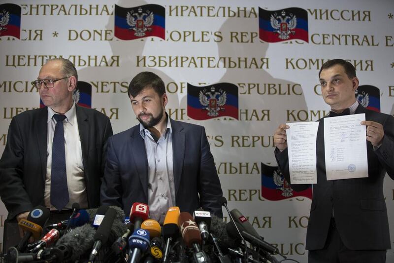 Co-chairman of the Presidium of the People's Republic of Donetsk Boris Litvinov, left, head of the elections commission of the so-called Donetsk People's Republic Denis Pushilin, and vote-counter Roman Lyagin, right, present the results of a separatist referendum in Donetsk, Ukraine, on May 12, 2014. Alexander Zemlianichenko / AP Photo