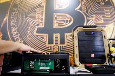FILE PHOTO: A cryptocurrency mining computer is seen in front of bitcoin logo during the annual Computex computer exhibition in Taipei, Taiwan, June 5, 2018. REUTERS/Tyrone Siu/File Photo