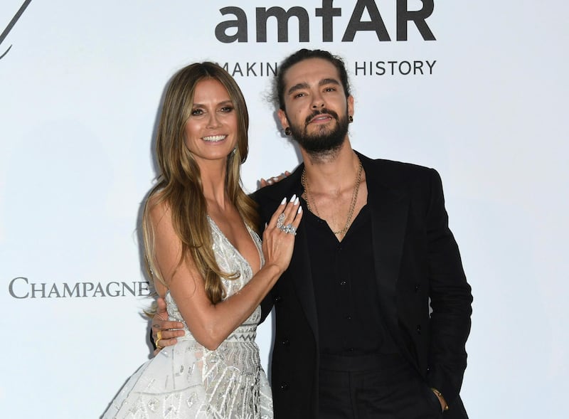 FILE - In this May 17, 2018, file photo, model Heidi Klum, left, and musician Tom Kaulitz pose for photographers upon arrival at the amfAR, Cinema Against AIDS, benefit at the Hotel du Cap-Eden-Roc, during the 71st international Cannes film festival, in Cap d'Antibes, southern France.  Klum, a 45-year-old German model, announced her engagement to Tokio Hotel guitarist Kaulitz in an Instagram post on Monday, Dec. 24. (Photo by Arthur Mola/Invision/AP, File)