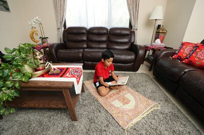 Mazen, 9, reads the Quran at home in Dubai. Chris Whiteoak / The National