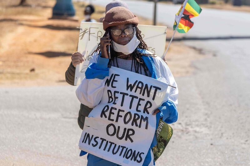 Zimbabwean novelist Tsitsi Dangarembga holds a placard during an anti-corruption protest march along Borrowdale road, on July 31, 2020 in Harare.  Police in Zimbabwe arrested on July 31, 2020 internationally-aclaimed novelist Tsitsi Dangarembga as they enforced a ban on protests coinciding with the anniversary of President Emmerson Mnangagwa's election. Dangarembga, 61, was bundled into a police truck as she demonstrated in the upmarket Harare suburb of Borrowdale alongside another protester.
 / AFP / ZINYANGE AUNTONY
