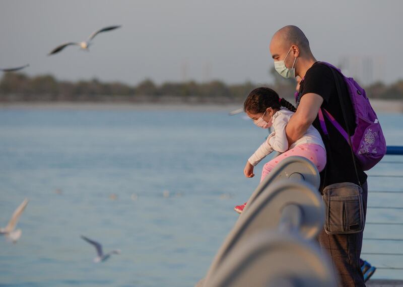 Abu Dhabi, United Arab Emirates, January 30, 2021.  A father and his daughter feed the seagulls as the sun sets along the Corniche on a Saturday.
Victor Besa/The National 
For:  Stand alone/Stock Images