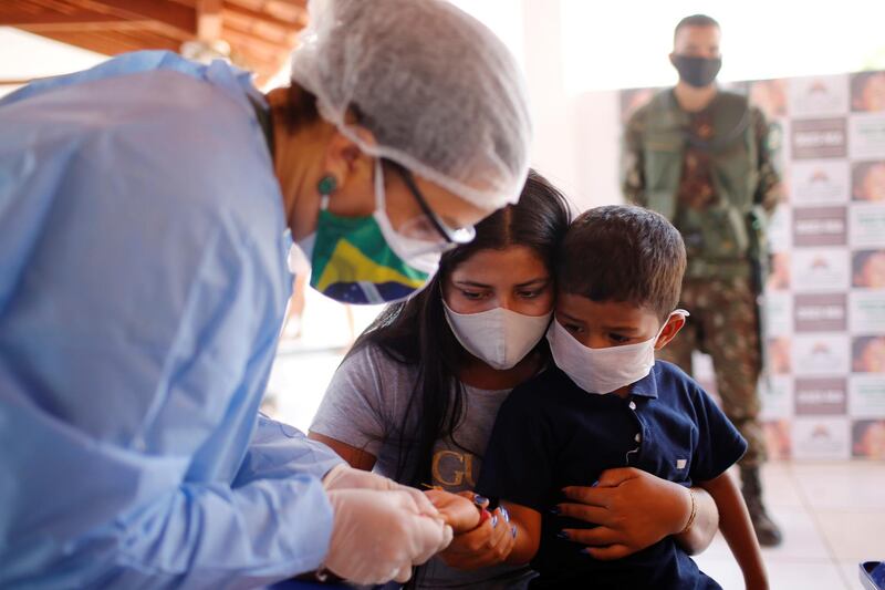 A member of the Brazilian Armed Forces medical team examines a child from the Guajajara indigenous ethnic group, amid the spread of the coronavirus disease, at a community school in the indigenous village of Morro Branco in the municipality of Grajau, state of Maranhao, Brazil. REUTERS