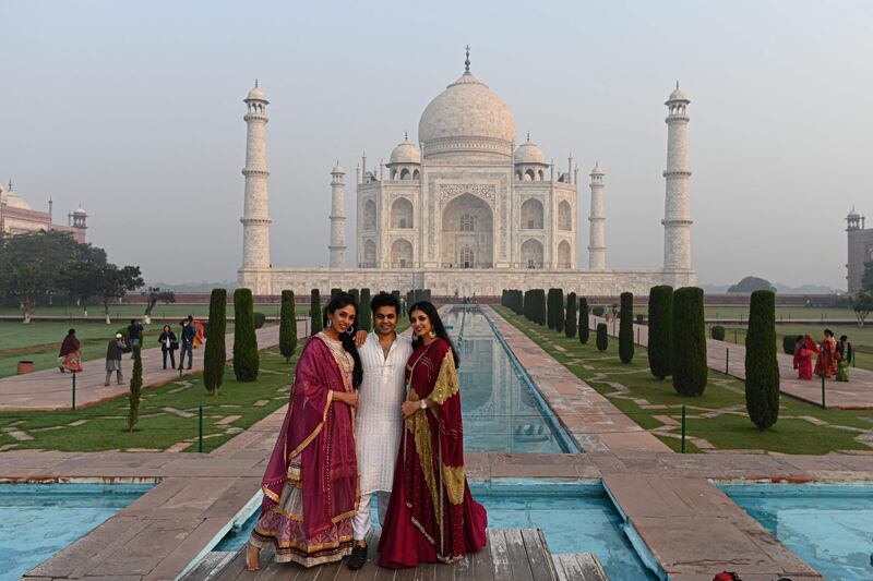 Visitors take pictures outside the Taj Mahal amid smoggy conditions in Agra.  AFP