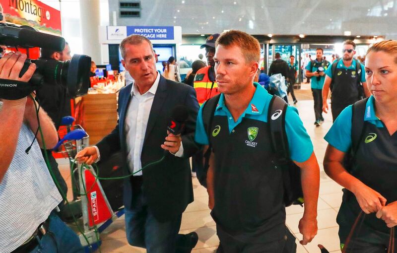 Australian cricket player David Warner, centre, departs from Cape Town International airport. Nic Bothma / EPA