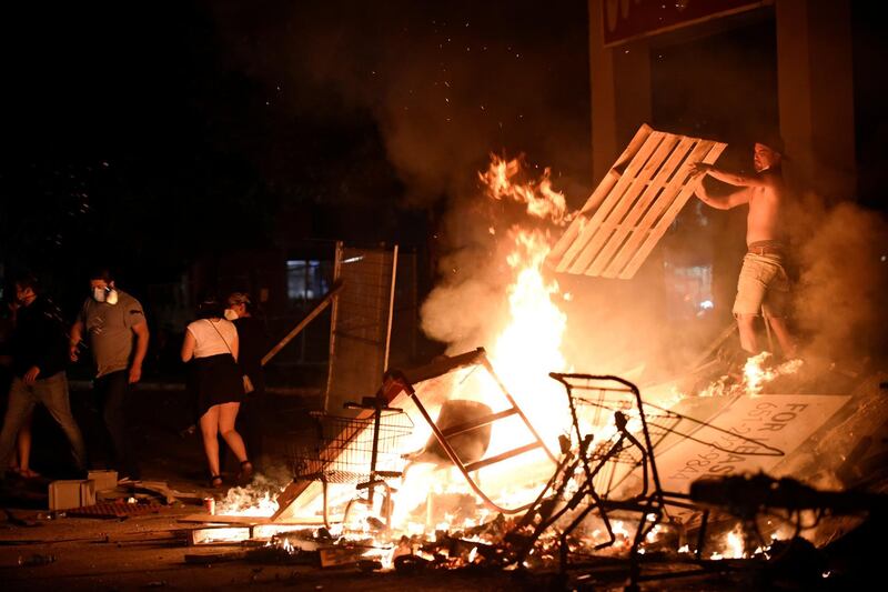 A protester adds wood to a fire barricade on 26th Ave S near the Minneapolis Police third precinct after a white police officer was caught on a bystander's video pressing his knee into the neck of African-American man George Floyd. Reuteres