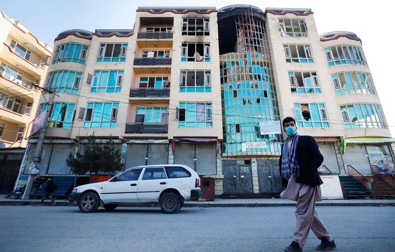 A man walks past a building where gunmen were hiding during an attack the day before, in Kabul, Afghanistan.  EPA