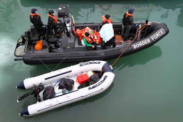 UK Border Force officers bring a group of migrants into port after they crossed the English Channel in a small boat. AP 