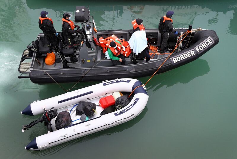 A group of people thought to be migrants are brought into port by Border Force officers following a small boat incident in the Channel, at Dover southern England, Monday March 8, 2021. (Gareth Fuller/PA via AP)