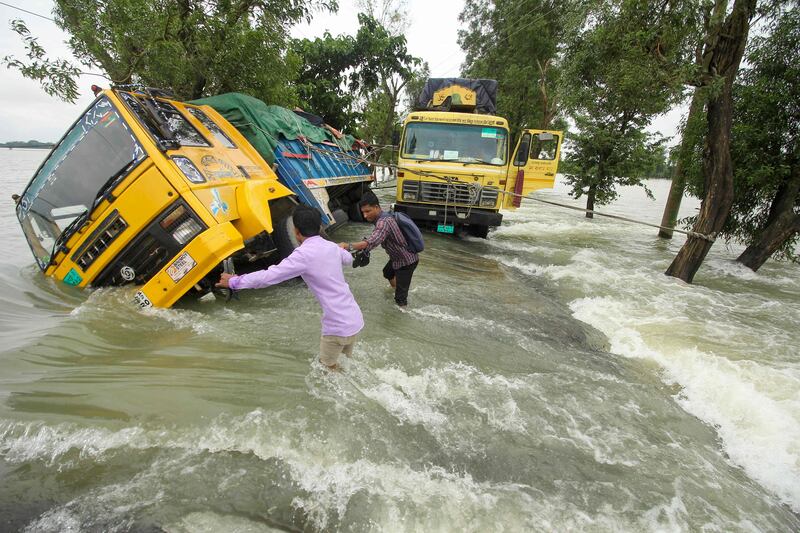 Residents brave fast-flowing floodwater as they pass stranded trucks in Sunamganj, north-eastern Bangladesh. Large areas of the country and parts of neighbouring India are under water following heavy rain. AFP