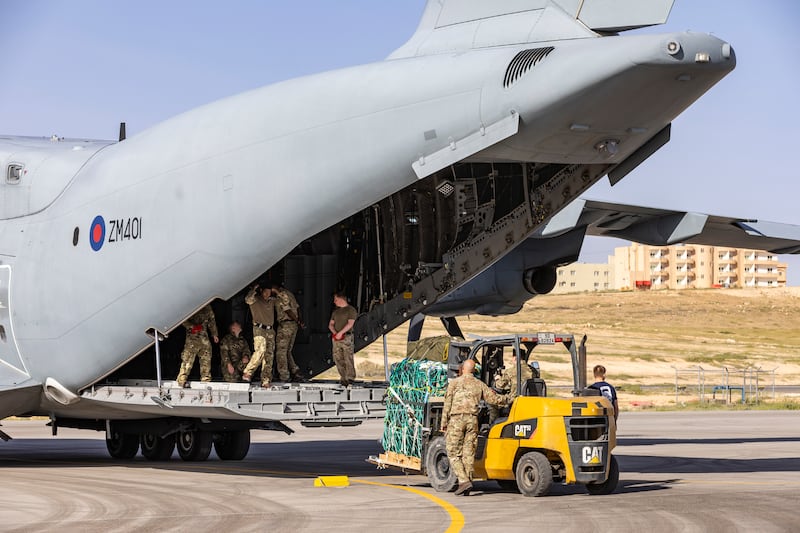 UK military personnel load the aid on to an A400M Atlas aircraft.