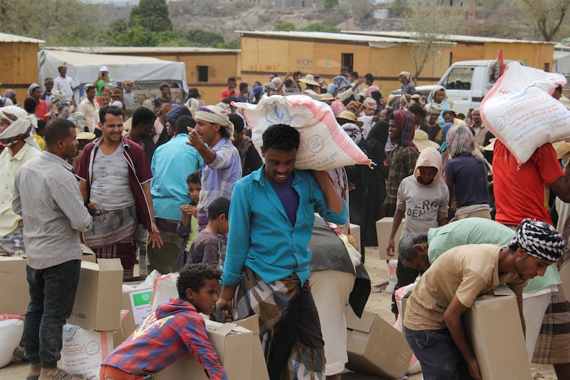Internally displaced people collect food aid distributed by a charity in Taez.
