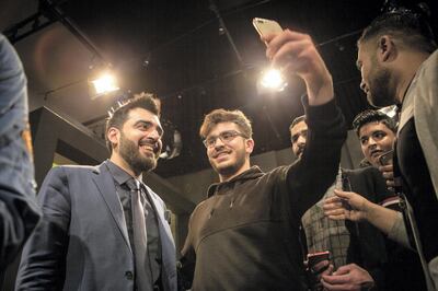 Ahmed Albasheer (left) take a selfies with a group of fans. Albasheer is an Iraqi comedian most prominently known for being the founder and anchor of the Albasheer Show, a news satire and talk show television program.