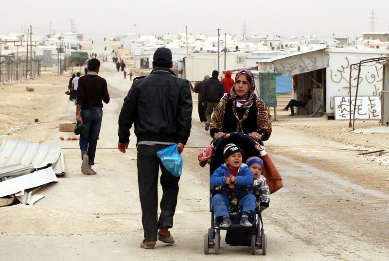 A Syrian refugee woman pushes a stroller at the Zaatari refugee camp, near the Jordanian border with Syria. Khalil Mazraawi / AFP / March 8, 2014