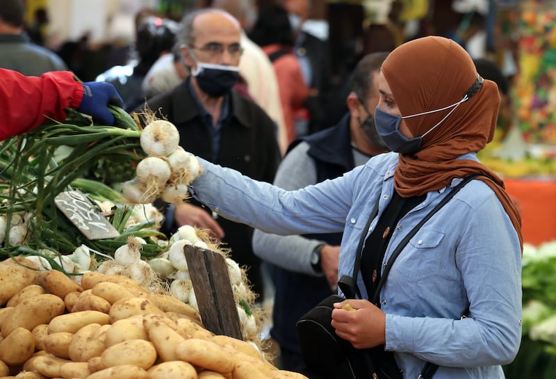 A Tunisian woman buys vegetables at a market in Tunis, Tunisia, 13 April 2021. EPA