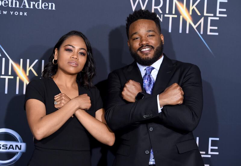 Zinzi Evans, left, and Ryan Coogler gesture the "Wakanda Forever" symbol from the film "Black Panther" as they arrive at the world premiere of "A Wrinkle in Time" at the El Capitan Theatre on Monday, Feb. 26, 2018, in Los Angeles. AP