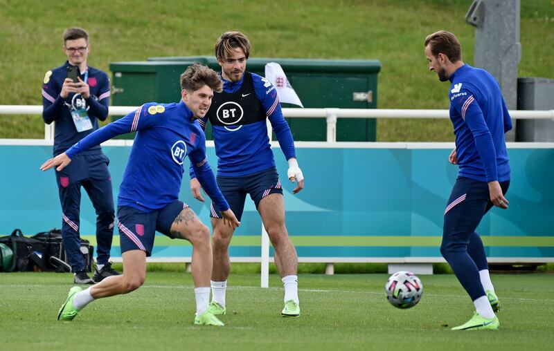 John Stones, left, and Jack Grealish close down Harry Kane during a training session at St George's Park.