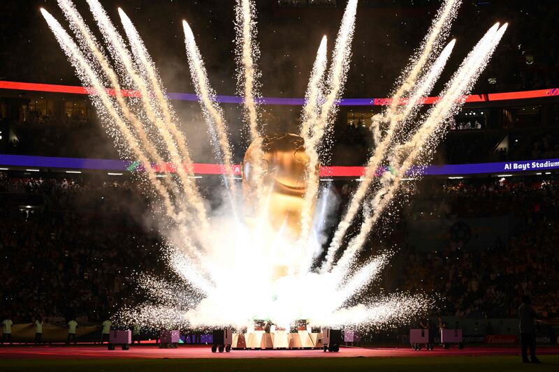 Fireworks explode around a replica of the World Cup trophy. AFP