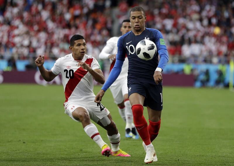 France's Kylian Mbappe, right, is challenged by Peru's Edison Flores. Natacha Pisarenko / AP Photo