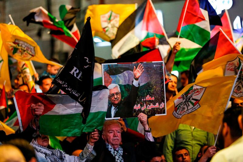 Palestinians wave Palestinian and Fatah flags and pictures of Abbas during a demonstration in a square in the West Bank city of Ramallah. AFP