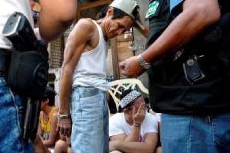 epa00671683 Filipino Joselito Avila (C) is handcuffed after trying to escape with illegal drugs paraphernalia from the scene of a government raid in Manila's Pasay City, Philippines on Sunday 19 March 2006. The Philippine Drug Enforcement Agency (PDEA) continues to act on reports of proliferation of illegal drugs in the country, as the agency downplayed a recent report from the United States government that the Philippines is becoming a haven for illegal drugs smugglers.  EPA/ROLEX DELA PENA