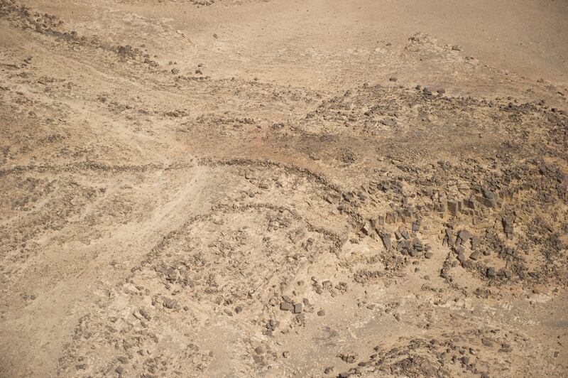 Aerial view of a V-shaped kite on the eroded eastern edge of the Harrat ’Uwayrid. The guide walls of this kite curve and converge towards a cliff edge, at the bottom of which a collapsed enclosure can be seen which may have assisted in trapping the target prey. Photo: Royal Commission for AlUla
