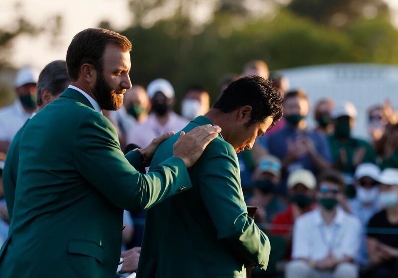 Japan's Hideki Matsuyama is presented with the green jacket by Dustin Johnson. Reuters