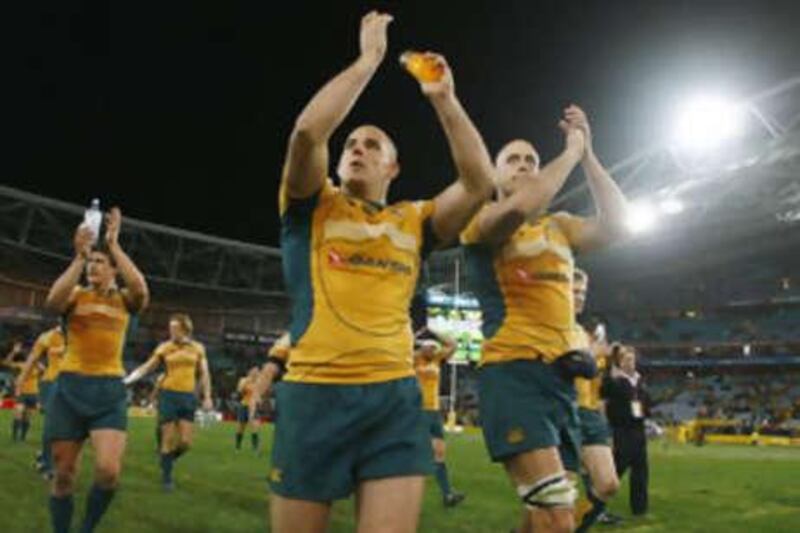 Australia's Stephen Moore, centre, and Nathan Sharpe, right, celebrate their team's victory over New Zealand in the Tri Nations.