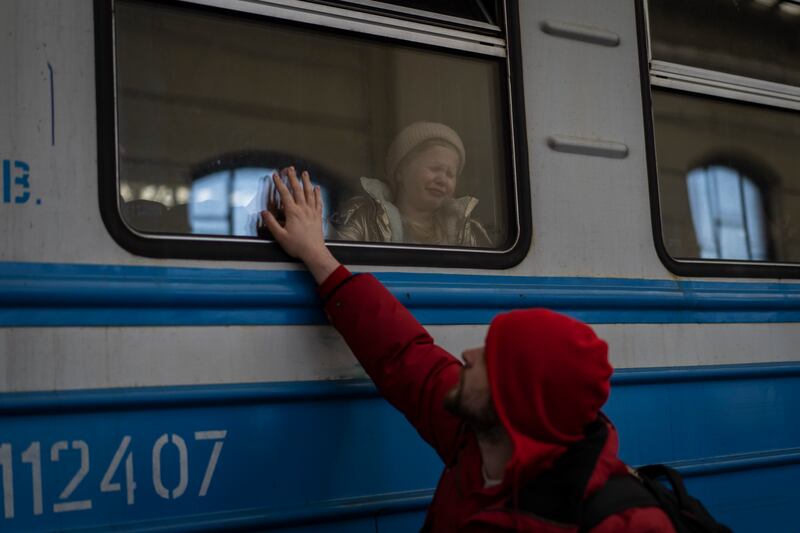 Displaced Ukrainians on a Poland-bound train bid farewell at Lviv, western Ukraine. AP