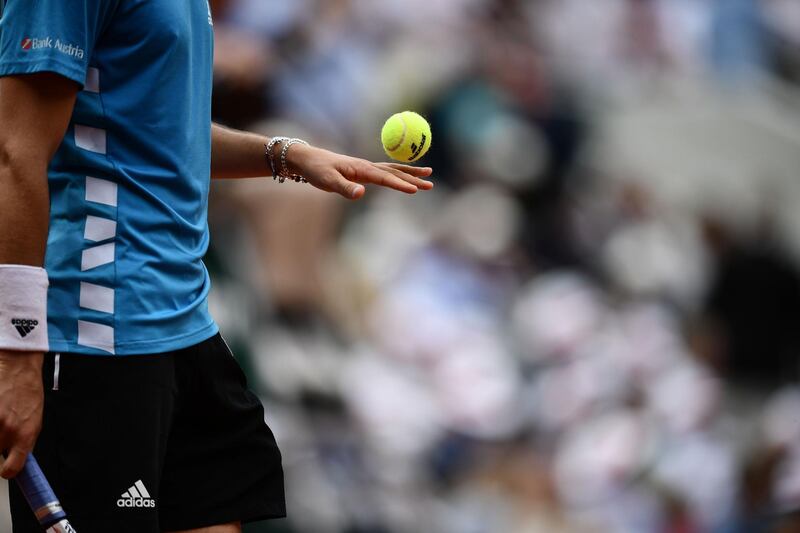 Thiem holds a tennis ball as he plays against Nadal. AFP