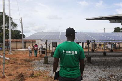 A Husk Power employee stands next to solar panels at the company's minigrid in Kiguna, Nasarawa, Nigeria. Thomson Reuters Foundation / Afolabi Sotunde