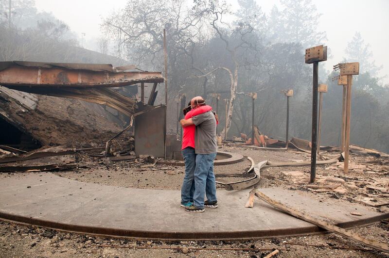 Rhonda Readen hugs her crying partner, Tim Shirley after they arrived to find their home in the Fountaingrove area of Santa Rosa totally destroyed in California. Randy Pench / The Sacramento Bee via AP