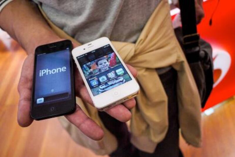 Customers holds the new Apple iPhone 5 smartphone in a telephone operator's shop in central Rome, on September 28, 2012. The new iPhone 5 broke records in its launch weekend with sales above five million, Apple said this week, but the figures were below some forecasts and pressured the company's share price. AFP PHOTO / ANDREAS SOLARO
 *** Local Caption ***  558624-01-08.jpg