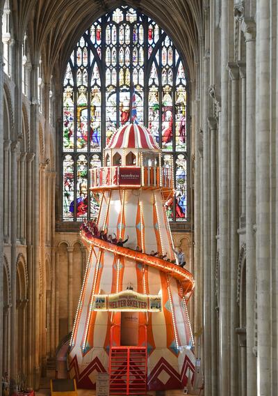 Choristers from Norwich Cathedral choir pose for a photo on large helter skelter is installed inside Norwich Cathedral, in Norwich, England as part of the 'Seeing It Differently' project which aims to give people the chance to experience the Cathedral in an entirely new way and open up conversations about faith, Thursday Aug. 8, 2019. (Joe Giddens/PA via AP)