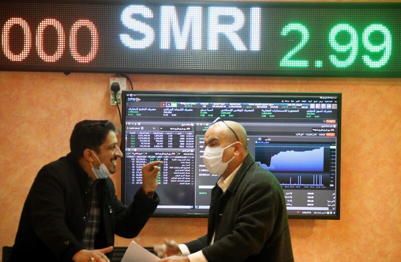 Iraqi investors look at an electronic board showing shares information at the Iraqi Stock Exchange in Baghdad. EPA