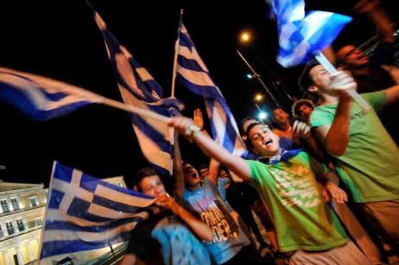 Greek supporters celebrate at the end of Euro 2012 championships football match between Greece and Russia in front of their parliament in central Athens on June 16, 2012.  A night before the election day Greek football team won 1-0 against Russia team.  AFP PHOTO / ANDREAS SOLARO
 *** Local Caption ***  789209-01-08.jpg