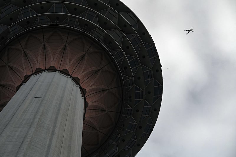 A base jumper leaps from the 300-metre high open deck of Malaysia's landmark Kuala Lumpur Tower during the International Tower Jump in Kuala Lumpur on February 3, 2023.  (Photo by MOHD RASFAN  /  AFP)