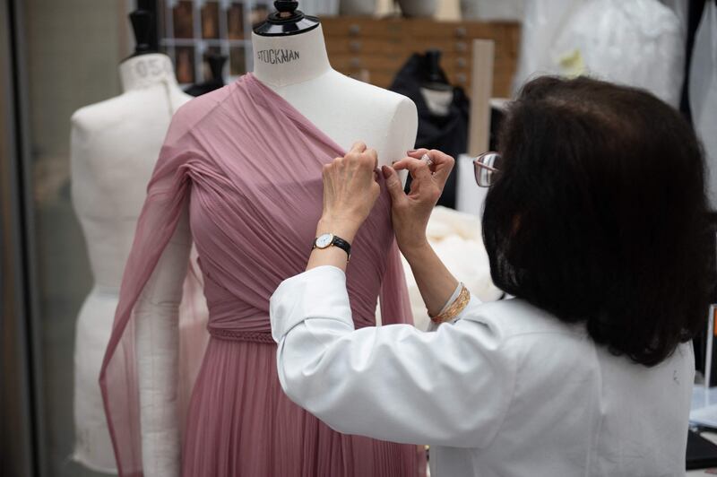 An employee works on the haute couture collection at the Christian Dior headquarters in Paris on July 3, 2021.