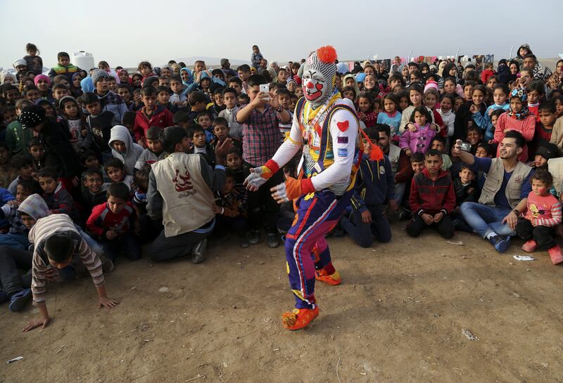 A clown performs during a New Year’s celebration for internally displaced children at the Hassan Sham camp, east of Mosul, Iraq. Khalid Mohammed / AP Photo