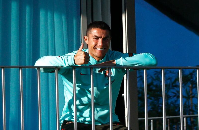 Portugal's Cristiano Ronaldo gives the thumbs up to photographers on the balcony in Lisbon during his team's training session for the upcoming Uefa Nations League match with Sweden. The Portuguese Football Federation announced on Tuesday that the Juventus striker tested positive for Covid-19. EPA