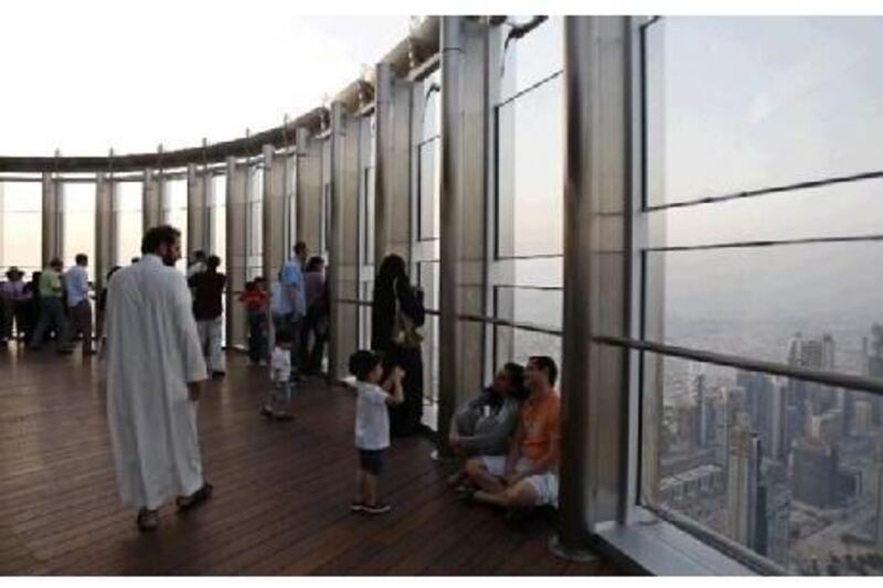 A boy takes a picture of his parents at the observation deck of the world's tallest building, the Burj Khalifa. The landmark is one of the many exciting draws for tourists. Kamran Jebreili / AP Photo