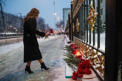 A woman places flowers at the entrance of the Kazakh embassy in Moscow, for the 164 people killed during the riots in Kazakhstan, in Russia, January 10. EPA